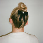 model wearing Mini Iconic Velvet Bow Barrette in Noir in hair