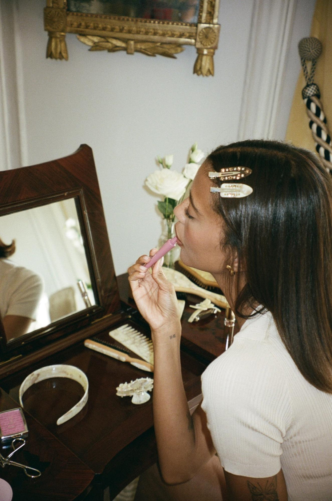 model looking in mirror and applying lip balm while wearing chantilly popstar clips in hair