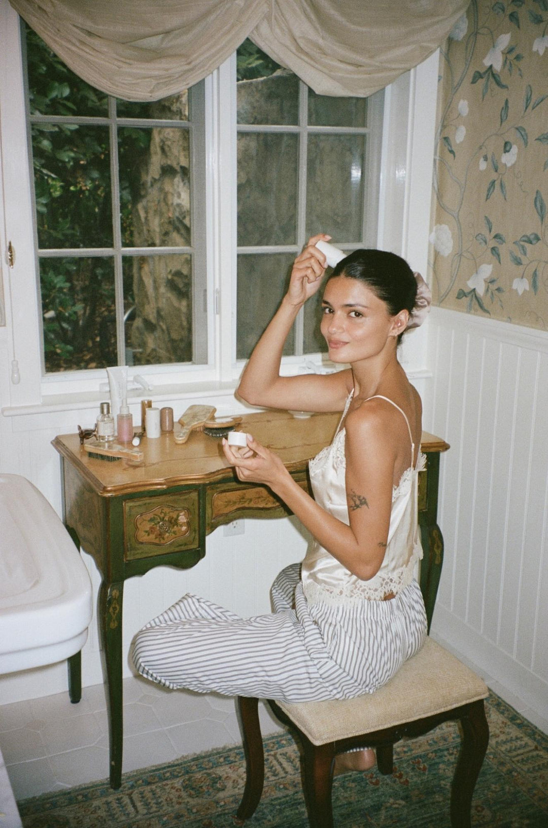 model leaning on bathroom sink while brushing hair with mini boar brush in chantilly