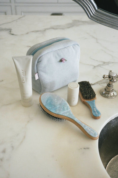 dream creme with blue sugar brushes and pouch on bathroom sink