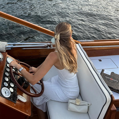 model wearing Lil Effing Clip in Buttercream in hair while piloting a sea vessel