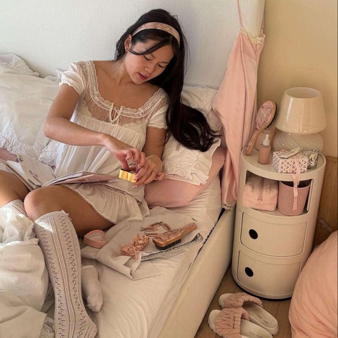 model sitting on bed with Wide Starlet Headband in Pink Chantilly in hair